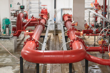 Red pumps of water supply system in basement of building.