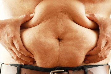 The overweight and bulky man held his stomach with his hands and squeezed the fat.