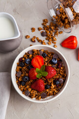 Granola with and berries for healthy breakfast. Top view. Bowl of granola with strawberry and blueberries, served with milk - 441646862