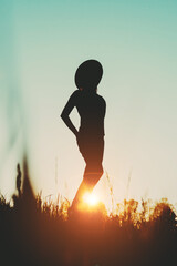 Silhouette of a girl in a hat at sunset - 441648059