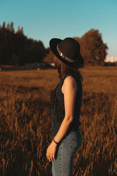 Girl in a hat at sunset Back view
