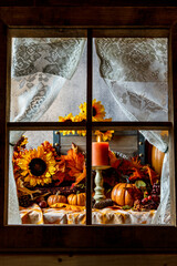 vertical fall still life of pumpkins and sunflowers through window