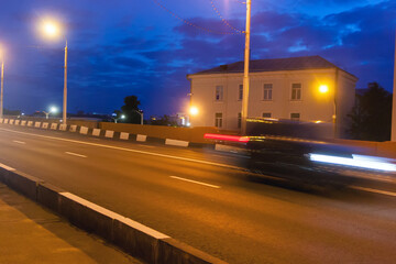 Motion of a blurred car along the overpass in the evening.