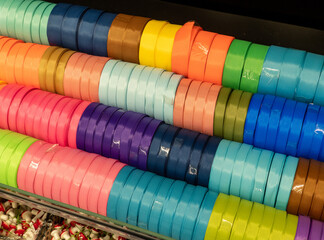 Textural silk ribbons on a shelf in a store. Multi-colored ribbons in the shop for needlework.