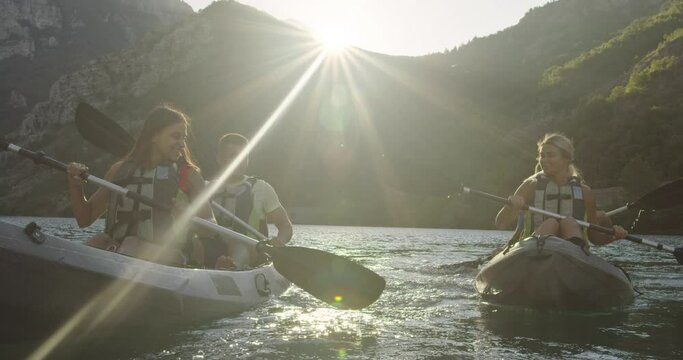Kayak rowing slow motion. Kayaker woman and man kayaking in a beautiful landscape. Kayakers practice sports in a kayak at the lake with friends. Aquatic sports during summer.