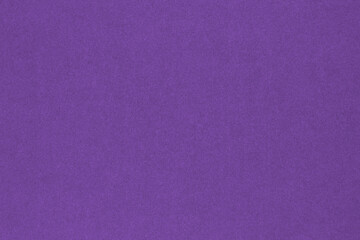 Purple colored paper texture. Deep violet background. Bright summer wallpaper. Textured surface, fibers and irregularities are visible. Top-down