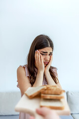 An Caucasian young woman feels bad, has an upset stomach, bloating due to gluten intolerance....