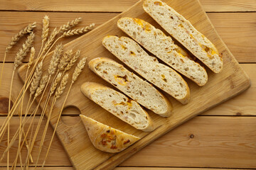 Loaf of organic bread on wooden background with cheese and ham. Fresh whole grain bread. Natural food concept.