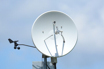 Weather station satellite dish anemometer and equipment against cloudy sky - obrazy, fototapety, plakaty