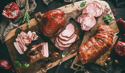 Assortment of cold meats products, ham, sausage, salami, parma, prosciutto, bacon on wooden cutting...