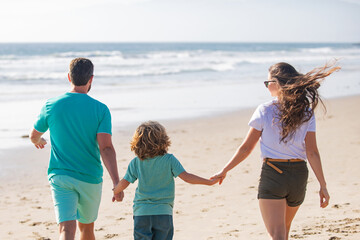 Young family walking on beach. Young happy family having fun together at the sea beach.