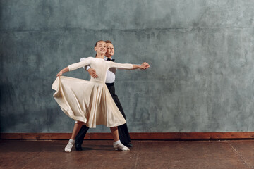 Young boy and girl dancers dances at ballroom dance Viennese Waltz. - obrazy, fototapety, plakaty
