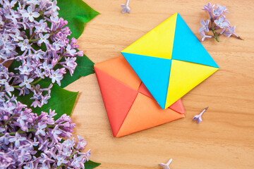 Beautiful abstract card with lilac flowers and origami, still life