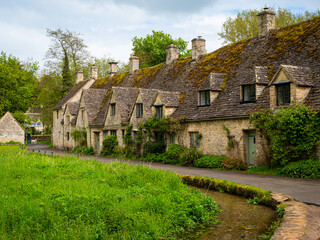 Arlington Row - historic 17th-century weavers' cottages, in Cotswold stone, beside a water meadow in Bibury village, near Cirencester, in Gloucestershire, UK.