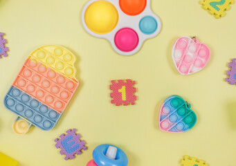 Popular silicone anti-stress pop it toys for a child on yellow violet green background. Trendy reliver stress Sensory Fidget Toy. Funny Bubble multicolored gadget for adults and children
