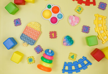 Popular silicone anti-stress pop it toys for a child on yellow violet green background. Trendy reliver stress Sensory Fidget Toy. Funny Bubble multicolored gadget for adults and children	