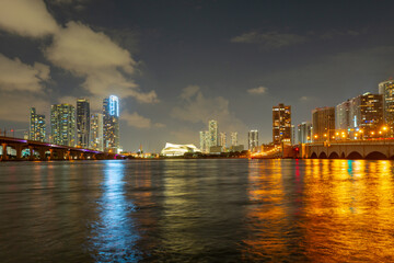 Fototapeta na wymiar Miami, Florida cityscape skyline on Biscayne Bay. Panorama at dusk with urban skyscrapers and bridge over sea with reflection.