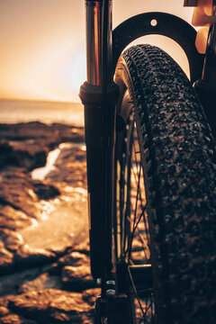 Detalle Bicicleta En La Playa, Con Fondo De Amanecer / Close Up Bicycle On The Beach, With Sunrise Background 