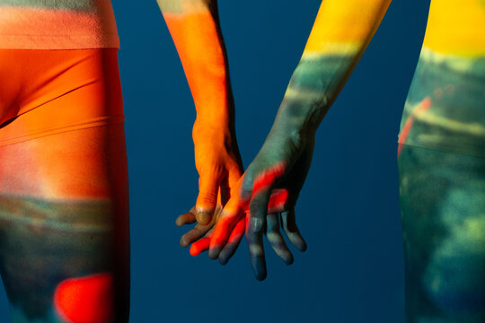 Closeup shot of couple hands with projector lights