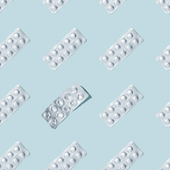 Foil packaging of pills and used pack seamless pattern on a blue background. Medical background.