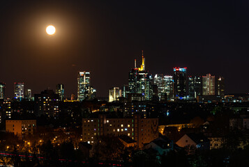 Fototapeta na wymiar Beautiful view on Frankfurt am Main (european finance center city) downtown skyline cityscape. Moon, supermoon during twilight blue hour, sunset, evening, night. Travel in Hesse. Hessen, Germany.