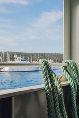 Fototapeta premium blue green ropes on Pacific Northwest ferry boat looking out at yacht