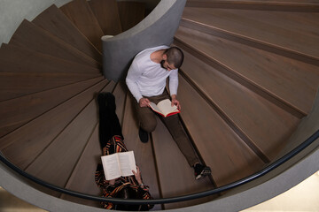 Happy Students Reading Books on Spiral Stairs