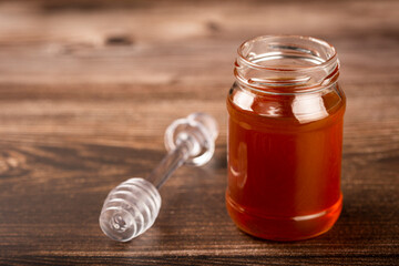 Honey in glass jar on the table.