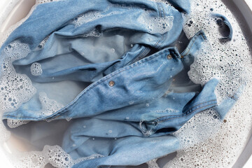 Jean shirt soak in powder detergent water dissolution, washing  cloth. Laundry concept