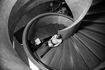 Happy Students Reading Books on Spiral Stairs