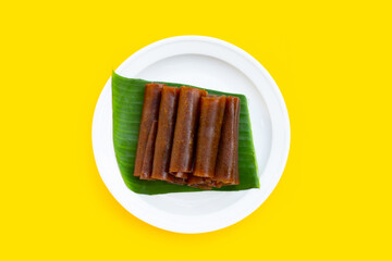 Dried mango paste on yellow background.