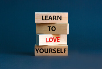 Learn to love yourself symbol. Concept words 'Learn to love yourself ' on wooden blocks on a beautiful grey background. Businessman hand. Business, psychological and learn to love yourself concept. - obrazy, fototapety, plakaty