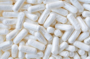 Fototapeta na wymiar Lots of white pills-capsules as a background