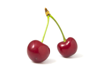 Two isolated red cherries on a white background.