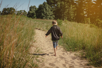 Young boy walking with bare feet on a trail at Indiana Dunes State Park