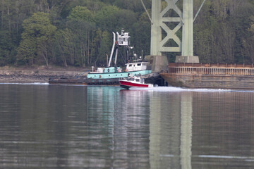 two boats under a bridge over calm water