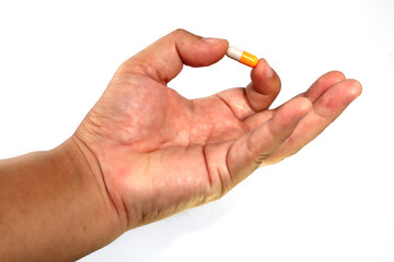 hand holding pill or capsule  isolated on white background