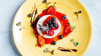Top view of the delicious Panna cotta dessert covered with strawberry jam on the plate