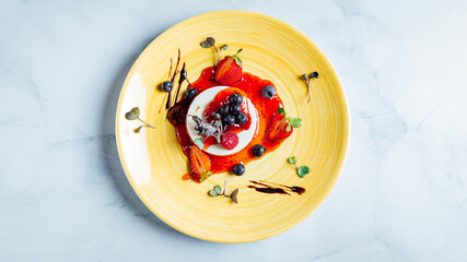 Top view of the delicious Panna cotta dessert covered with strawberry jam on the plate