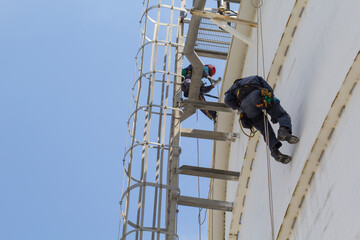 Male two worker rope access  inspection of thickness storage tank