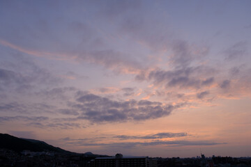 神戸市東灘区のマンション上層階から明け方の六甲山系。東の空から太陽が昇り空と雲がオレンジ色に染まる。六甲山と甲山の上雲の雲が美しい