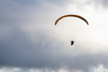 Adventurous People Flying on a Paraglider around the mountains. Savona, British Columbia, Canada.