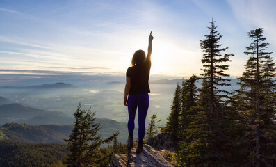 Adventurous Caucasian Adult Woman hiking in Canadian Nature over looking mountainous landscape....