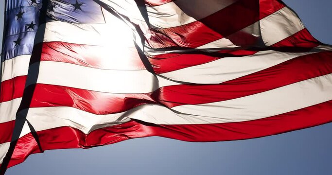 4k Slow Motion Backlit Real American Flag Waving In Wind Against a Deep Blue Sky