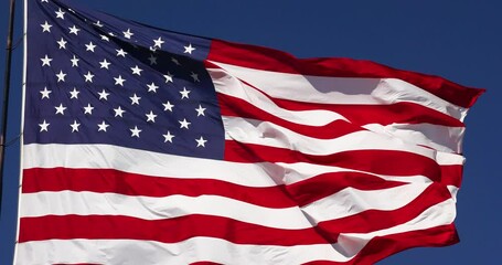 4k Slow Motion Real American Flag Waving In Wind Against a Deep Blue Sky