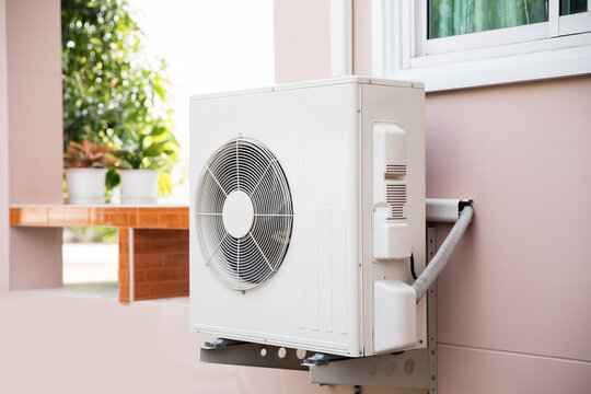 Air compressor, Close-up external split wall type of outdoor home air conditioner unit installed on outside building. Concepts of cool or heat or hot and air conditioning system maintenance.