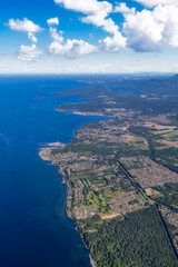 Aerial View of Qualicum Beach from an Airplane on the shore of Strait of Georgia in Vancouver Island, British Columbia, Canada. Colorful Blue Sky Art Render.