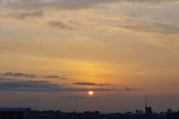 兵庫県神戸市東灘区の高層マンションの上層階からの夜明け。大阪生駒山から太陽が昇り、あたりはオレンジ色に染まり、ビル群がシルエットで浮かぶ。