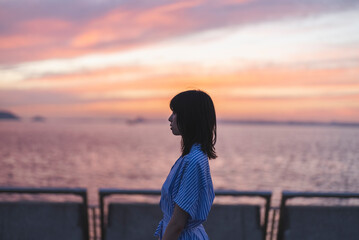 Fototapeta premium 夕暮れの海にいる女性
