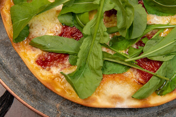 Brazilian pizza with sun-dried tomatoes, arugula and mozzarella